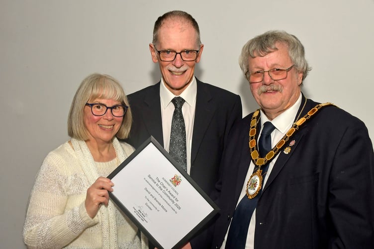 David and Brenda Moore, of Dunster, receive their community champions award certificate from Somerset Council chairman Cllr Mike Best.